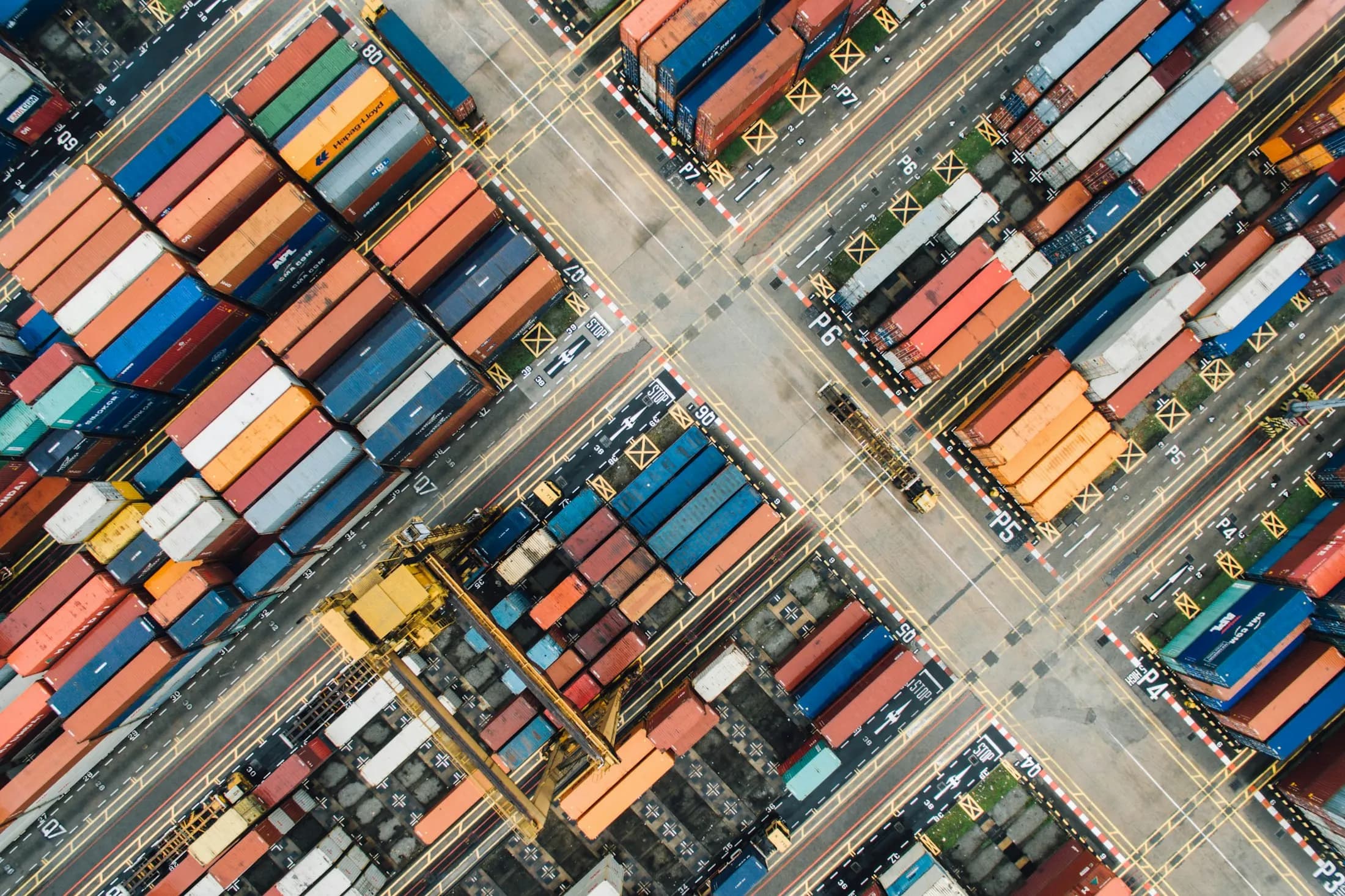Aerial view of stacked shipping containers at a port [seed]